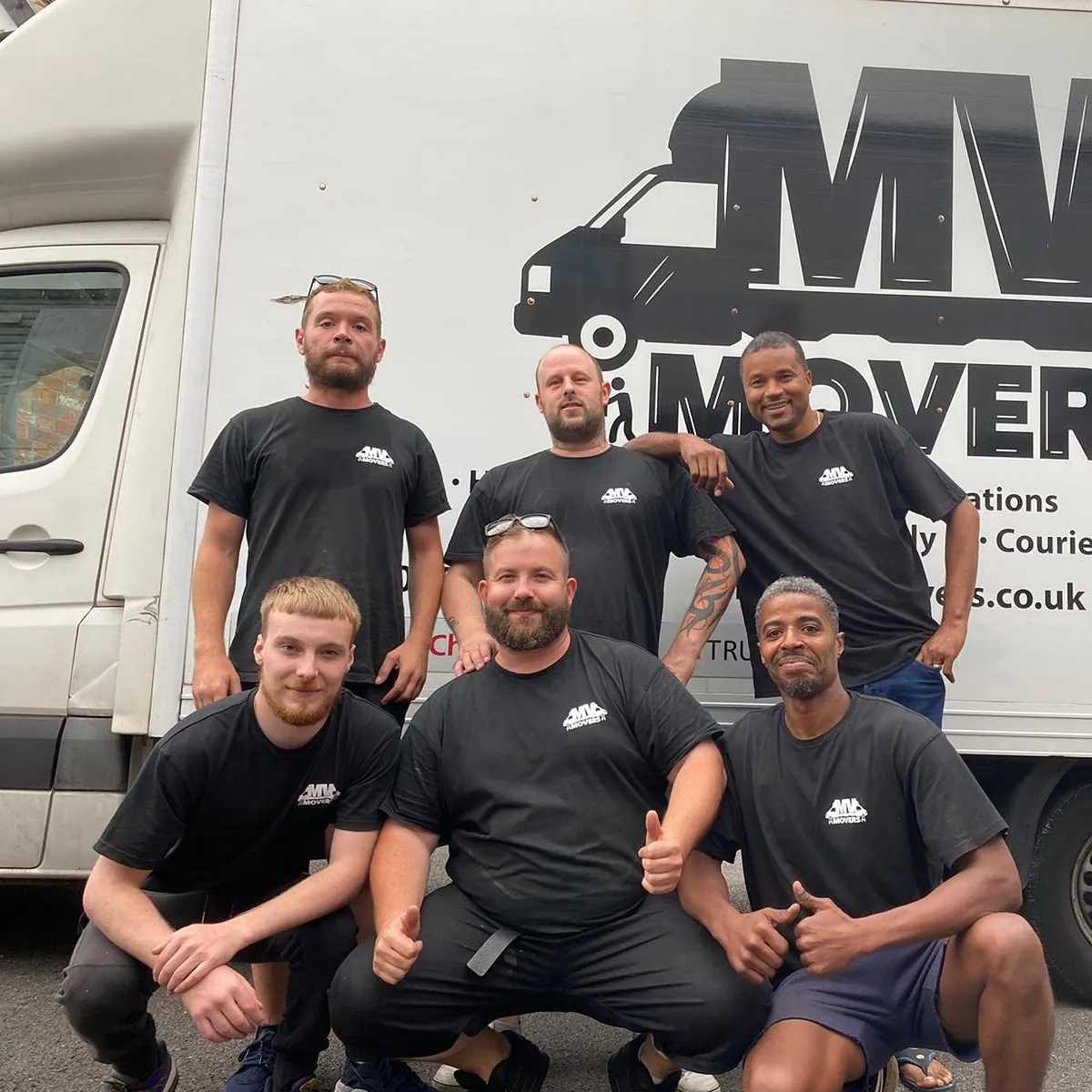 The MV Movers crew of seven in front of a van, Ealing removals team